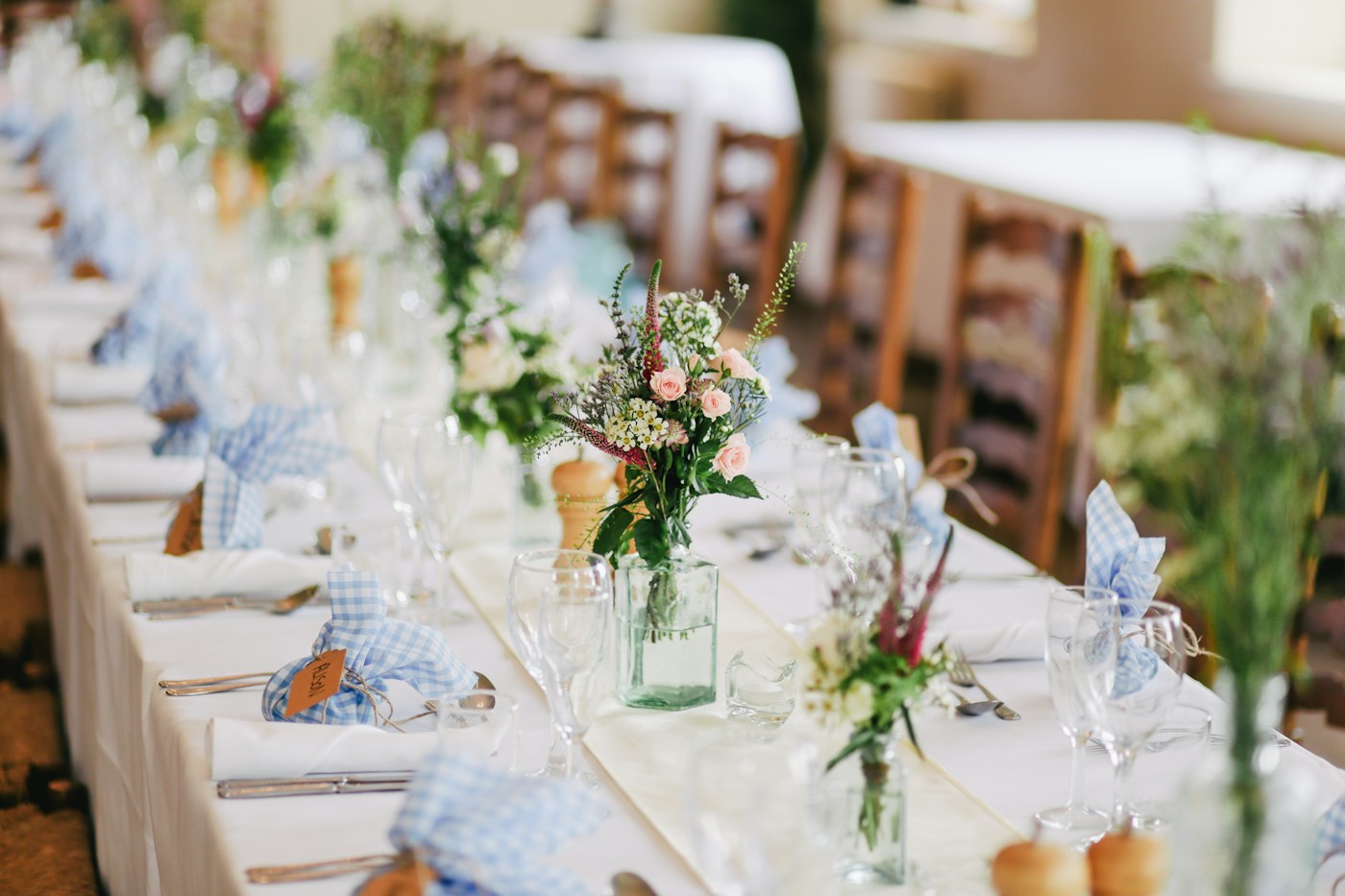 A reception table with delicate flowers and blue linens